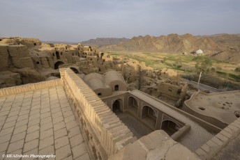 Overlooking the remains of the old citadel and a family mausoleum at Kharanaq Caravanserai