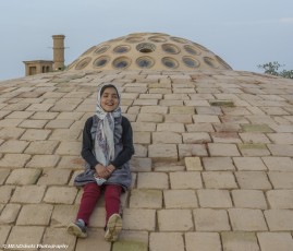 Girl atop the roof of the Kharanaq Caravanserai