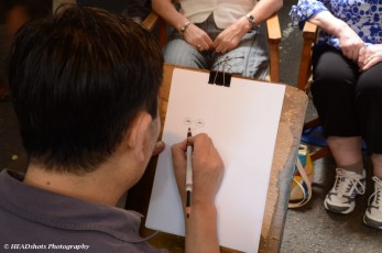 Who is he drawing - Melda or Trish?