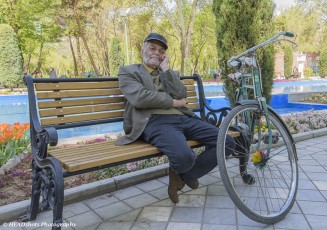 Well dressed cyclist relaxing in the park in Tehran
